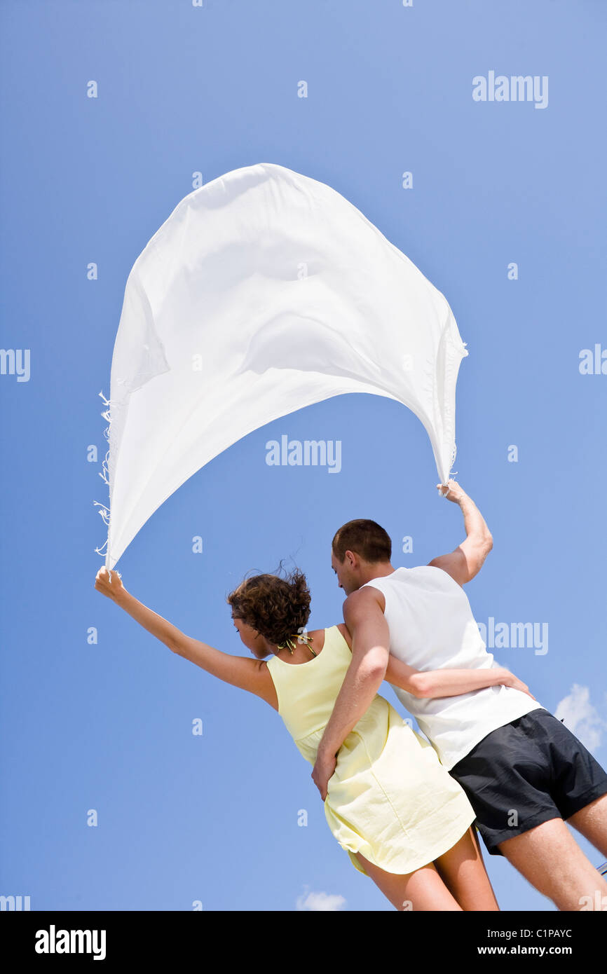 Young couple holding shawl above heads Stock Photo