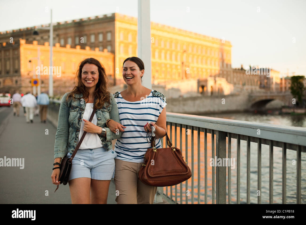 Two women walking through bridge, laughing Stock Photo - Alamy
