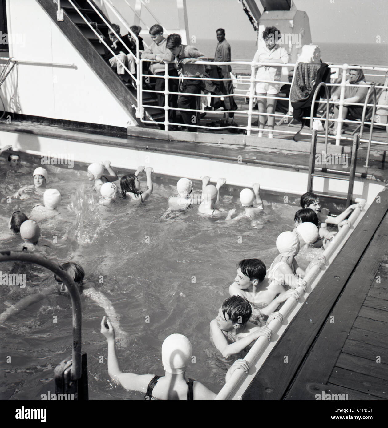British India cruise liner, 1950s. Passengers on board the ship enjoy a swim in the open pool. Stock Photo