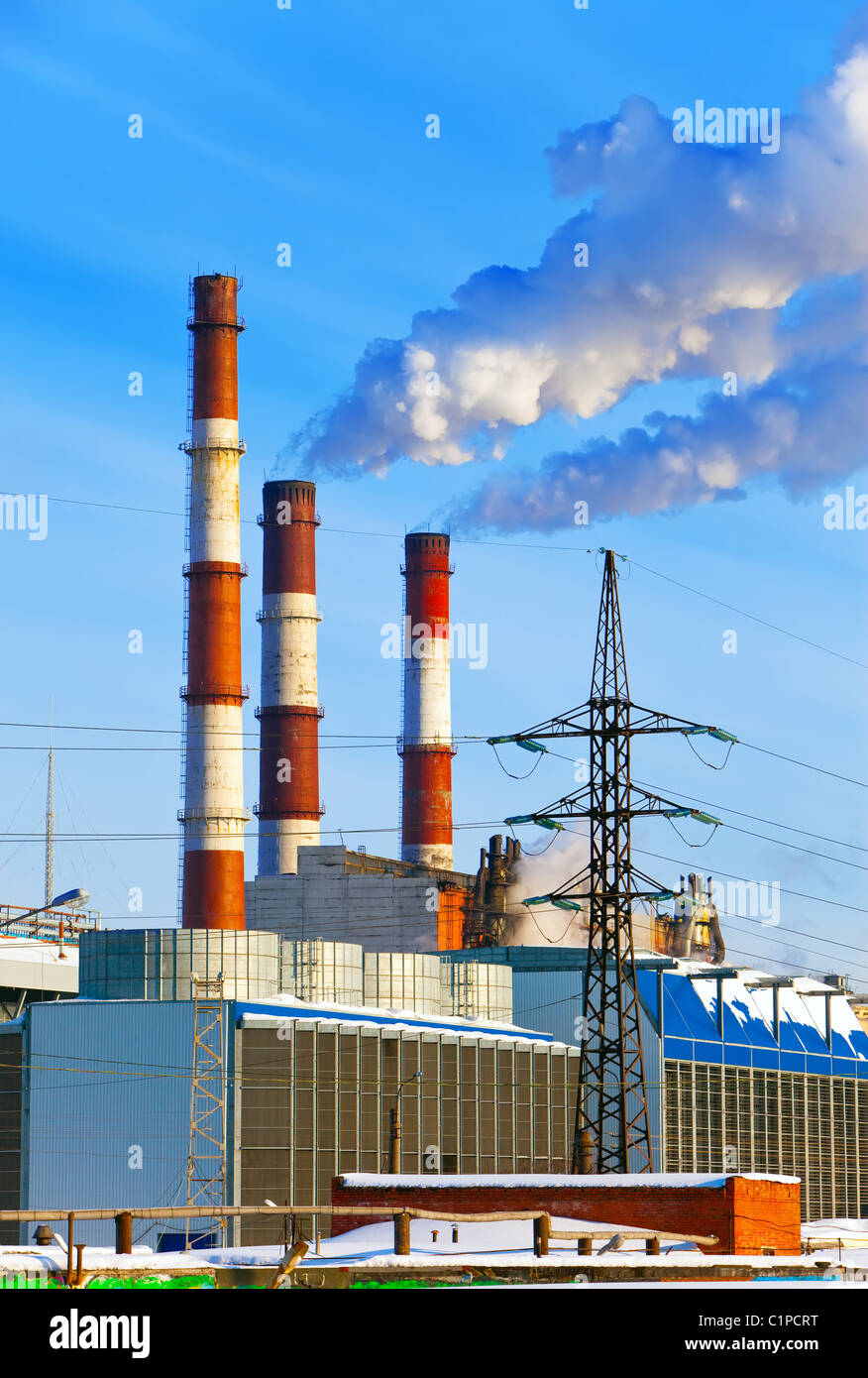 Thermal power station pipes smoke over a city. Stock Photo