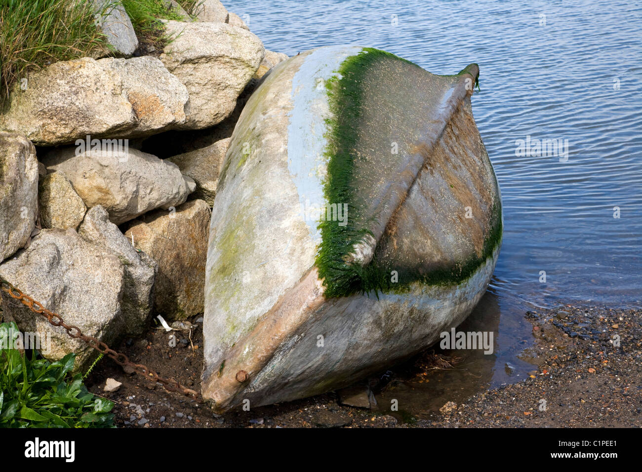 Upside down fishing boat chained to rock hires stock photography and