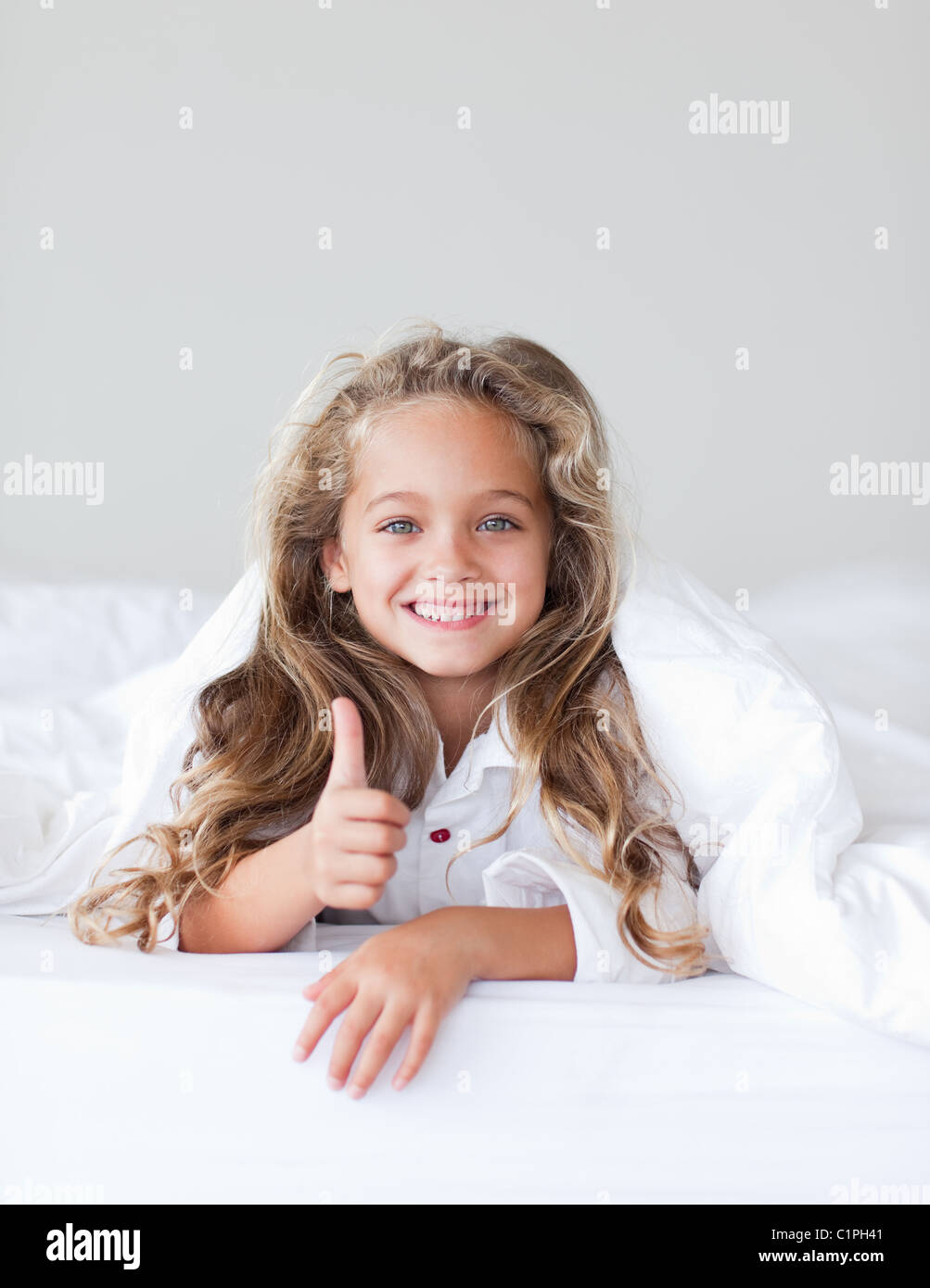 Smiling girl with thumbs up Stock Photo - Alamy
