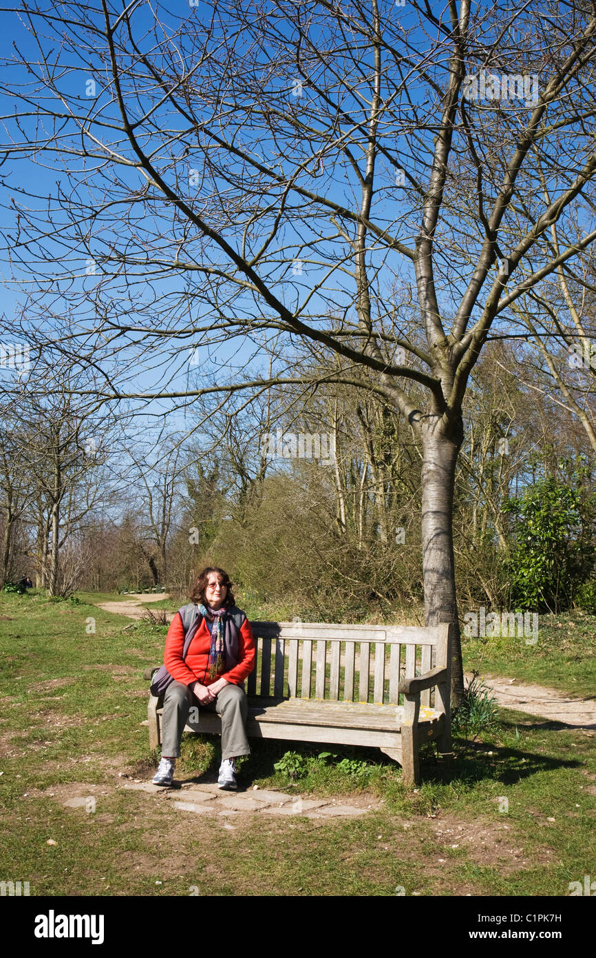 Woman sitting on a park bench hi-res stock photography and images - Alamy