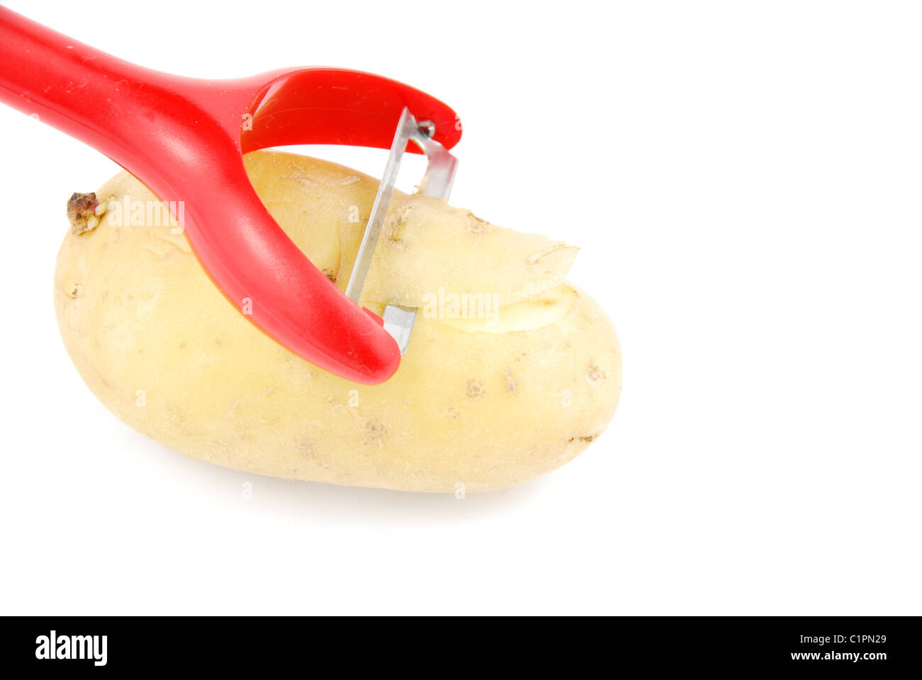 Peeling a potato with peeler on white Stock Photo Alamy