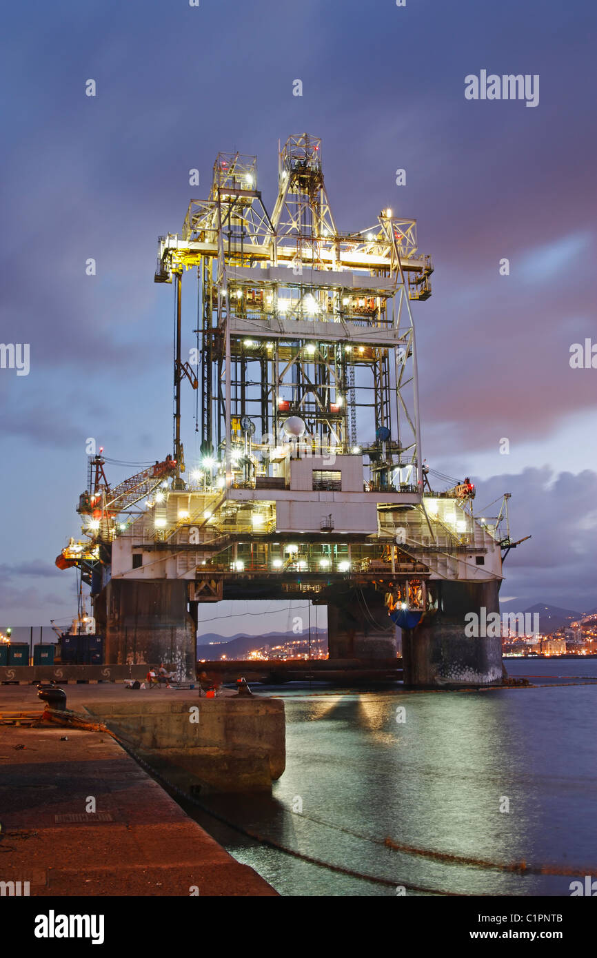 Oil rig at dockside at night Stock Photo