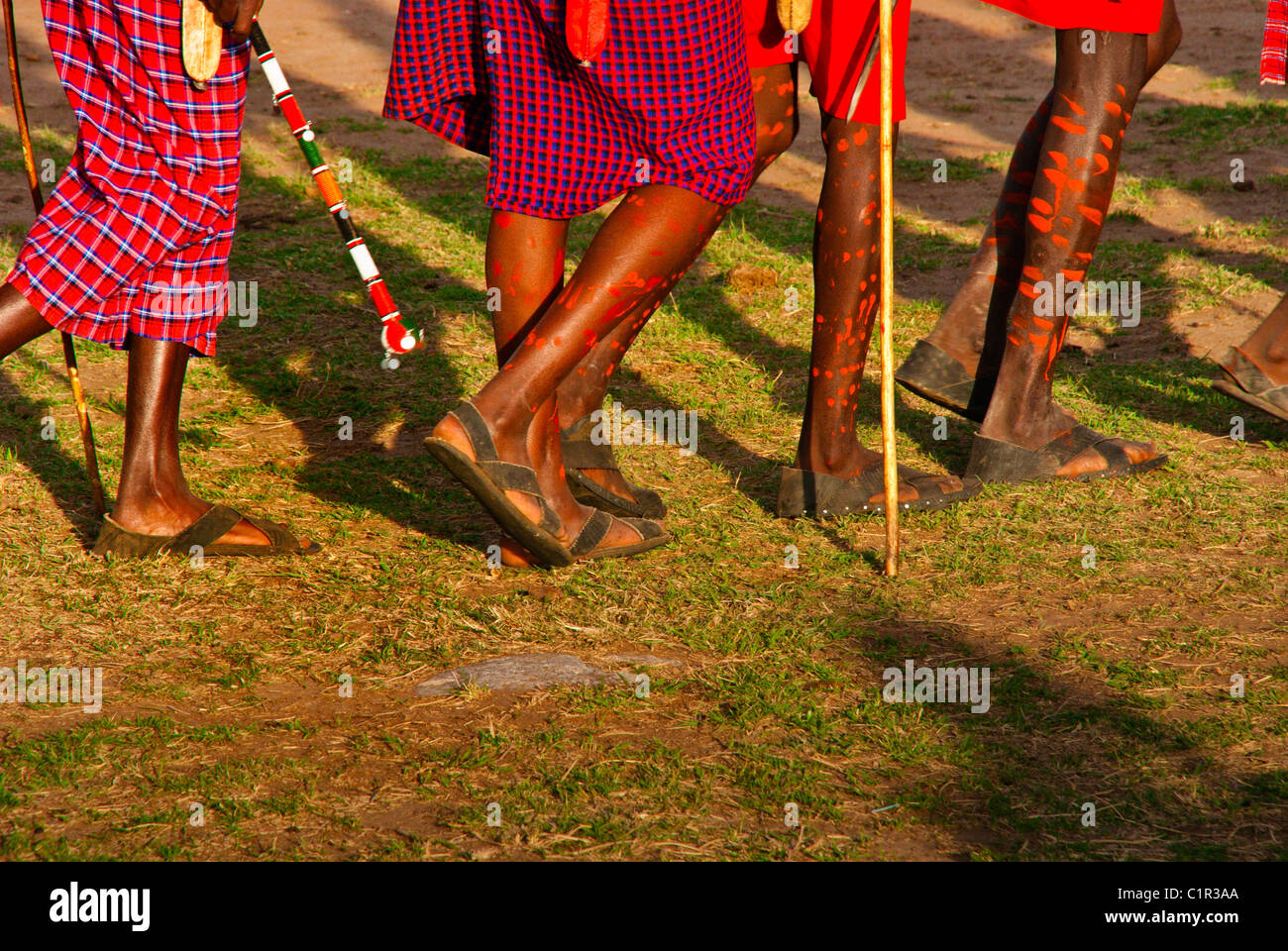 Masai men with decorated legs doing a welcome dance at a village outside the Masai Mara National Reserve, Kenya, Africa Stock Photo