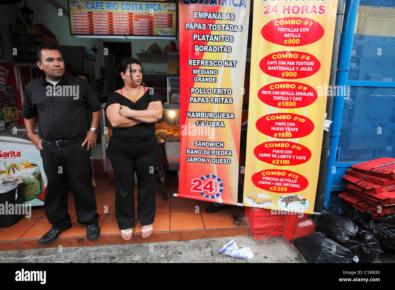 Small restaurant owners stand in front of their shop, San Jose, Costa Rica Stock Photo