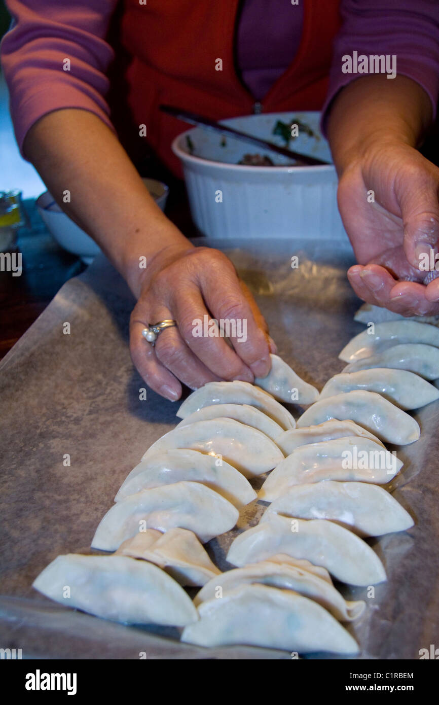 Chinese cook making tray of wor tip, also known as potstickers or pork dumplings Stock Photo