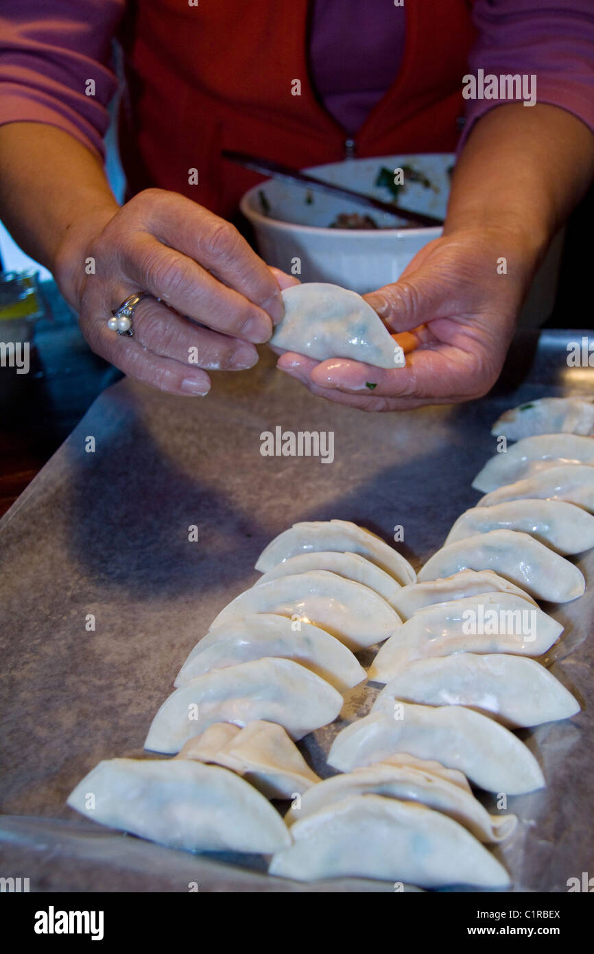 Chinese cook demonstrating how to make wor tip dumplings, also known as potstickers Stock Photo
