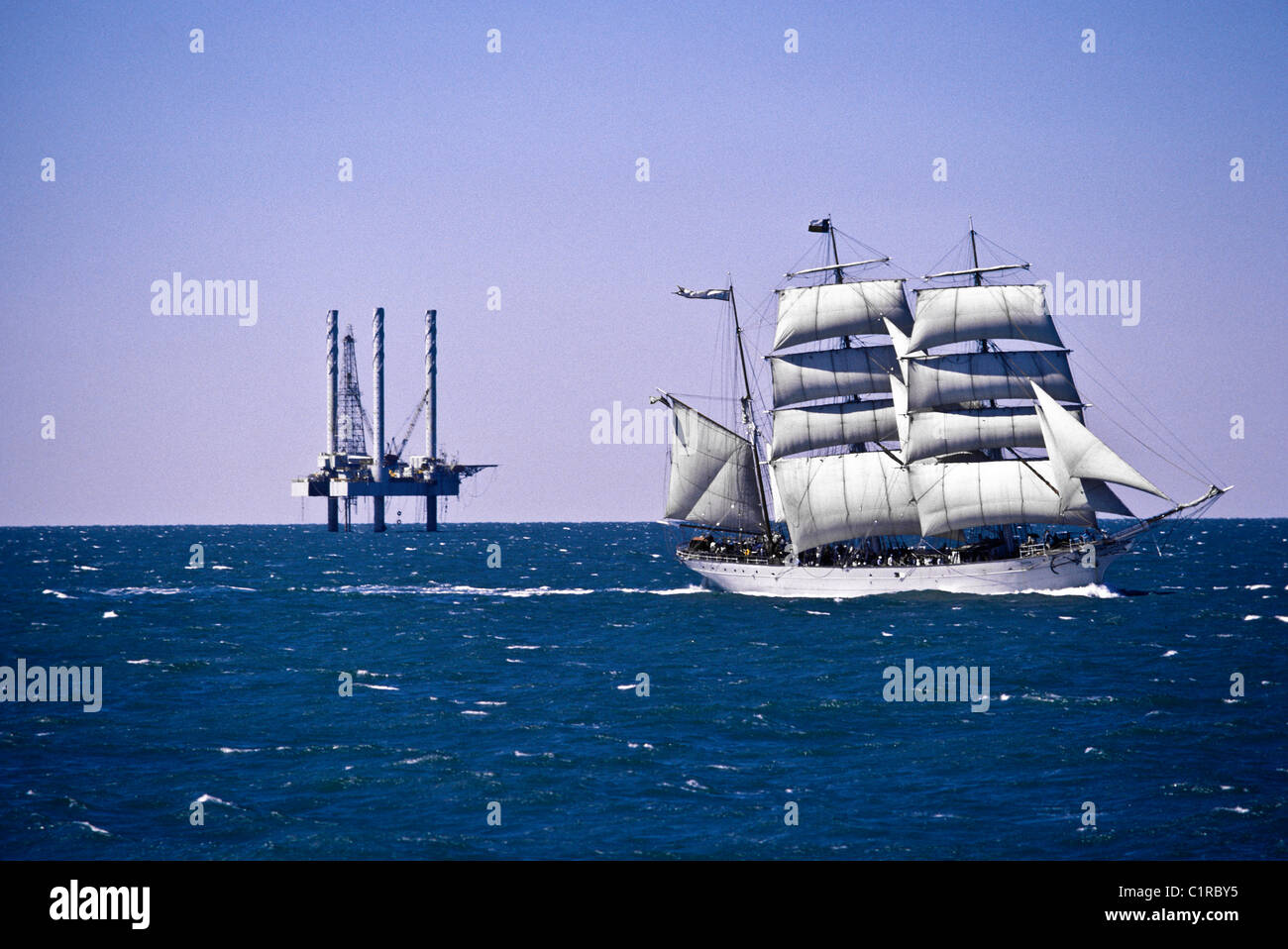 "Elissa", a three masted sailing tall ship, sailing near offshore oil rig platform in Galveston