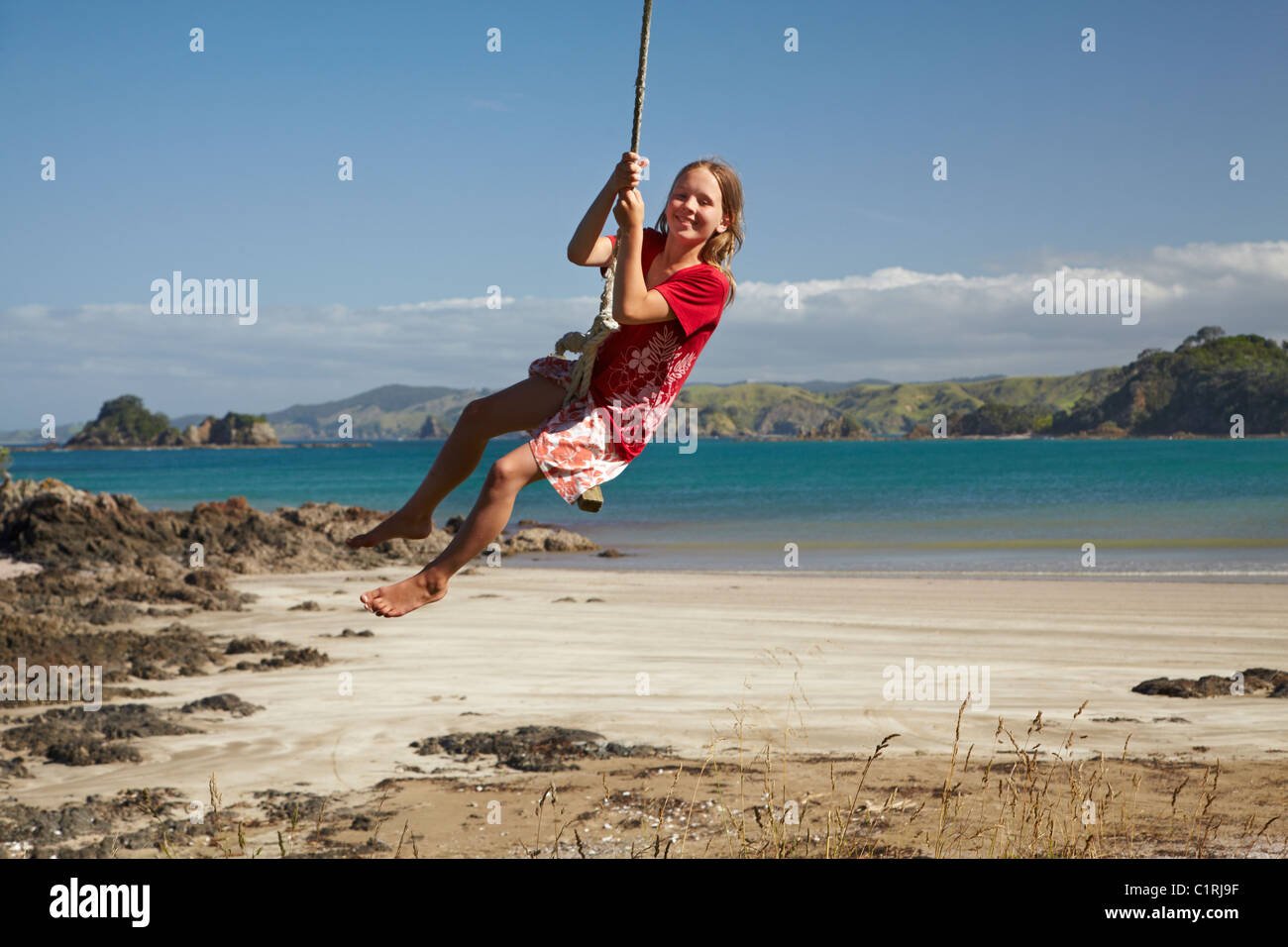 Girl on rope swing, Oakura Bay, Northland, North Island, New Zealand