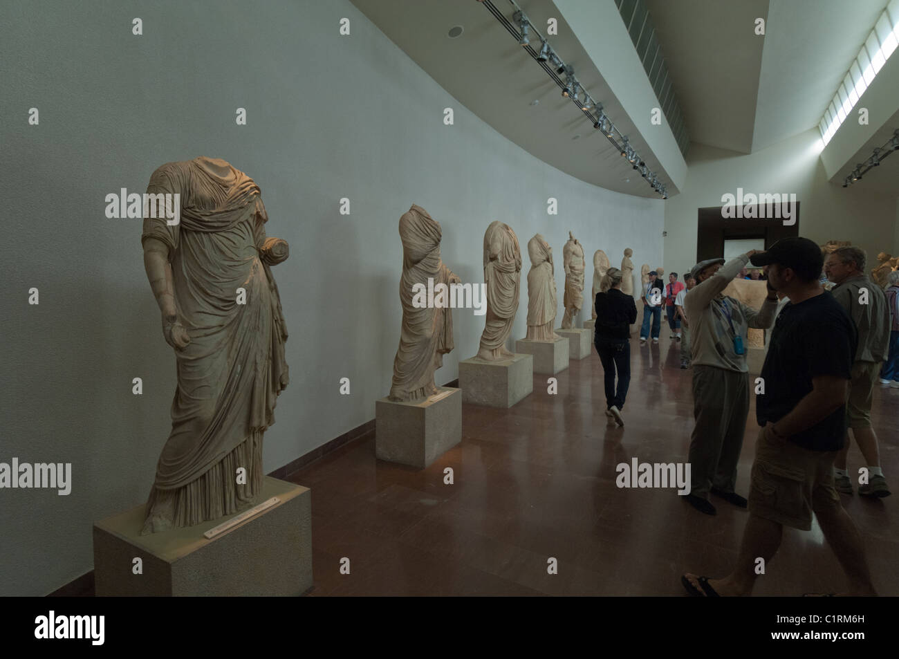 Tourist view fragile antiquities in a museum near the Olympic ruins by the city of Olympia, Greece. Stock Photo
