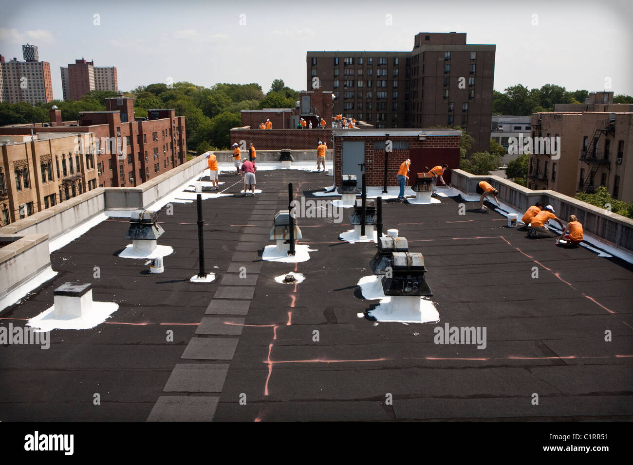 Volunteers paint Bronx, NY rooftop with specialized coating material