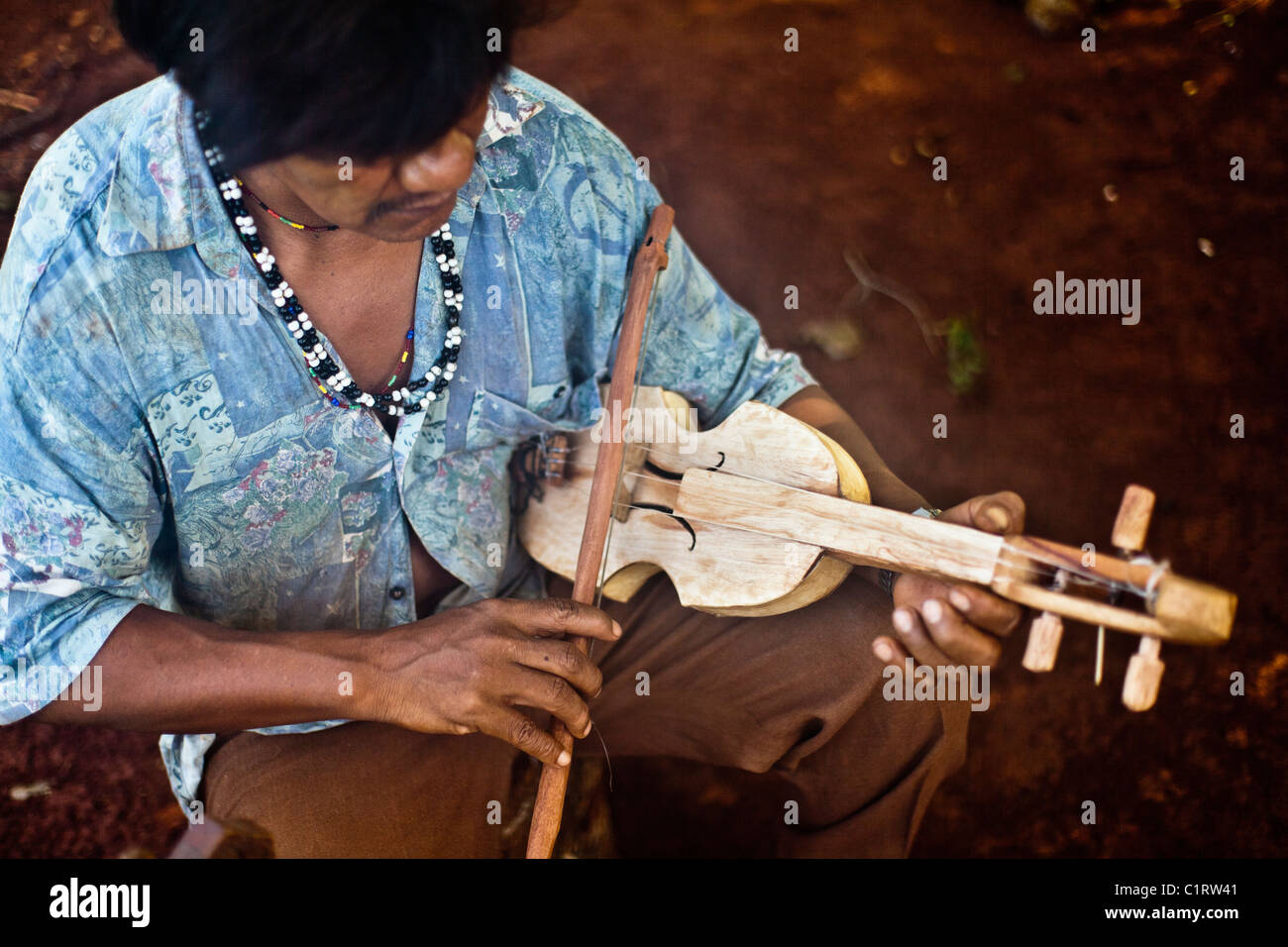 Mbya Guarani craftsman and musician from Misiones, Argentina, playing traditional music on violin (rabe). Stock Photo