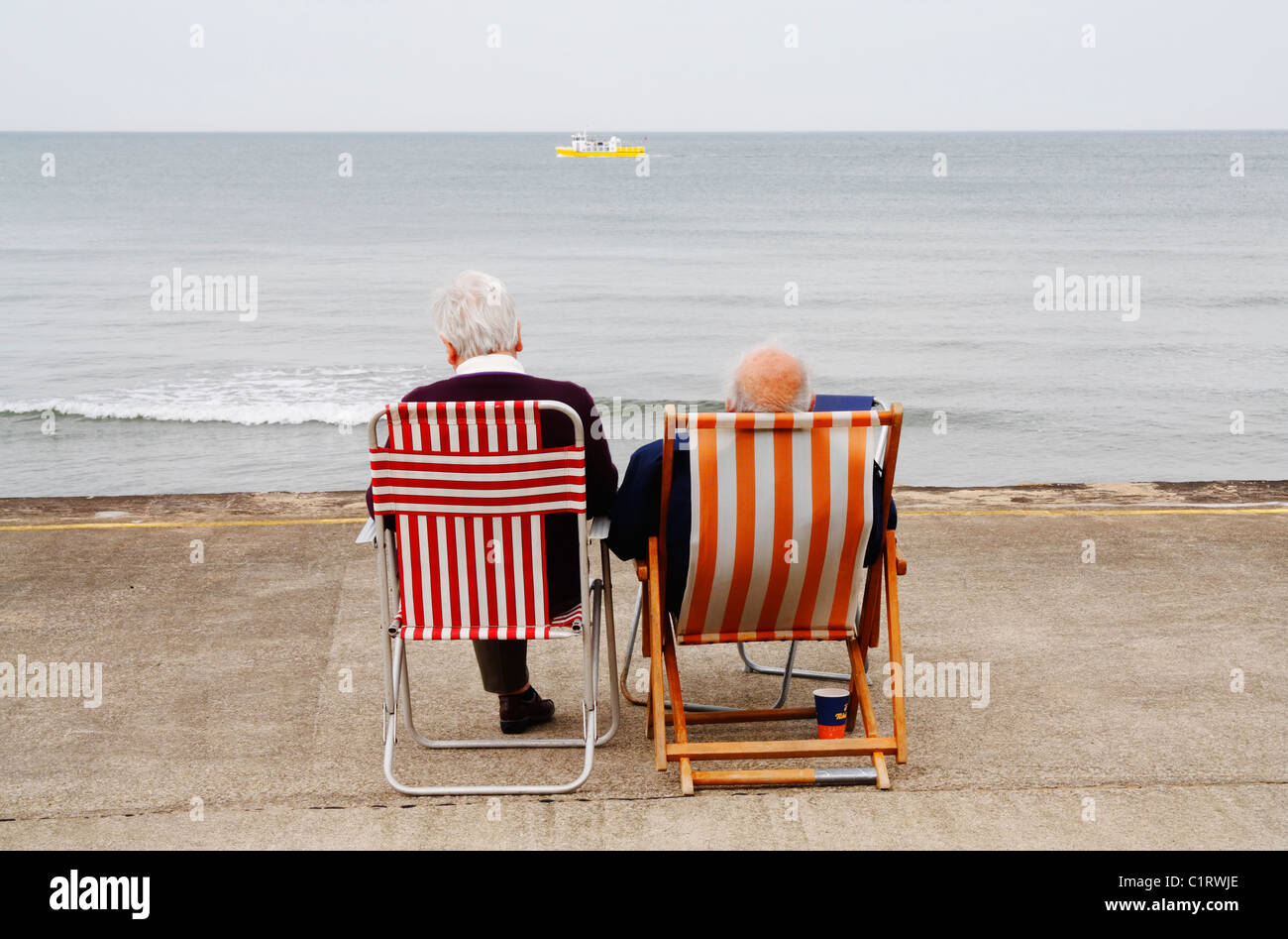 Elderly couple at Whitby on a grey day in May Stock Photo
