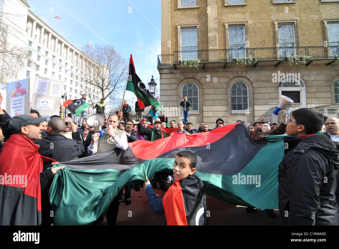 Libyan anti Gaddafi protest outside Downing Street waving flags chanting 'Thank you UK' Stock Photo