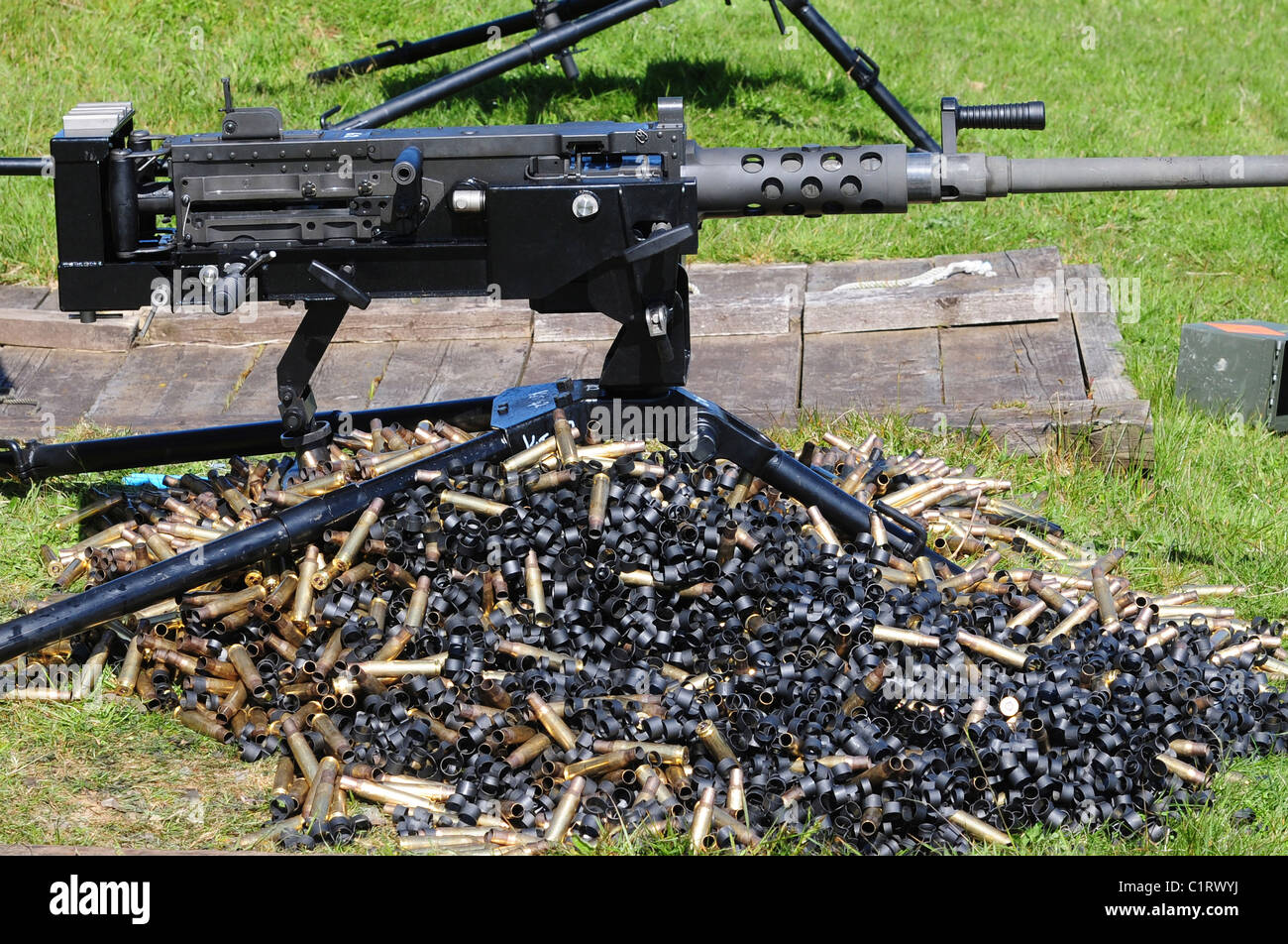 A .50 Caliber Browning Machine Gun with a pile of spent cases and links. Stock Photo