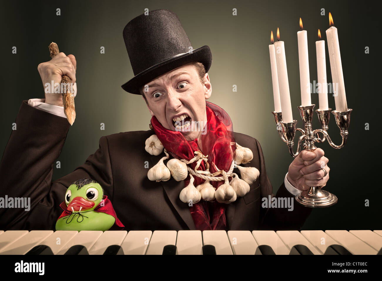 A man is trying to kill a vampire duck. The duck is a plastic toy. Stock Photo