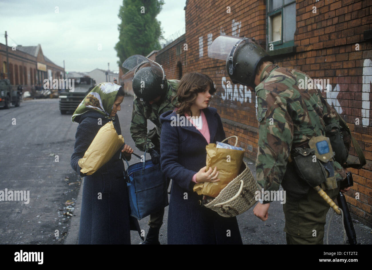 Belfast The Troubles. 1980s. British army soldiers stop and search woman mother and daughter, they are looking through their shopping bags. 1981 HOMER SYKES Stock Photo