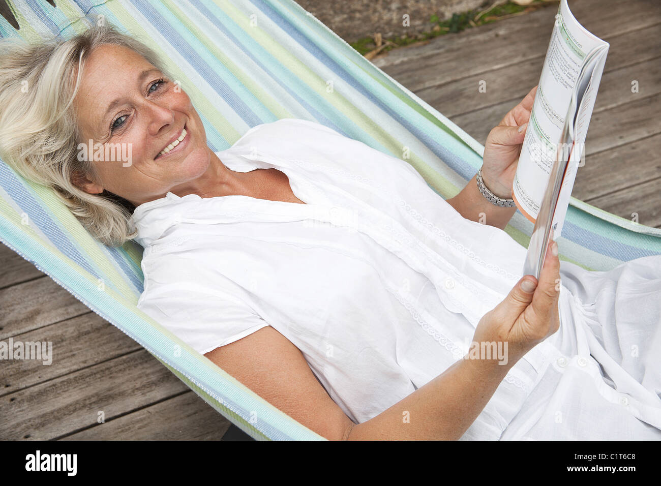 Mature woman relaxing in hammock, portrait Stock Photo - Alamy