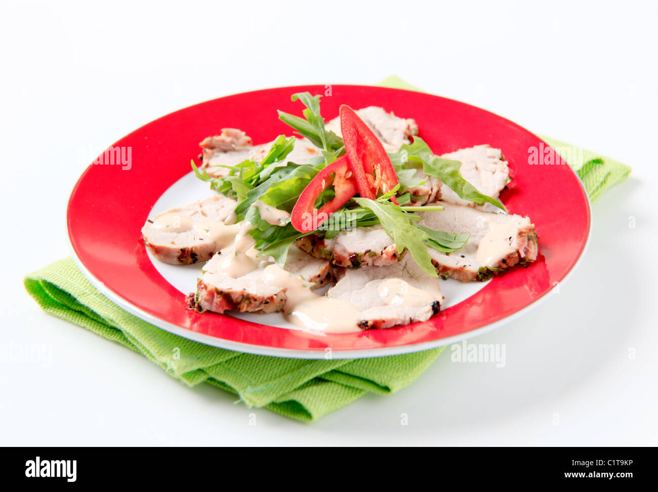 Roast pork tenderloin with greens and dressing Stock Photo