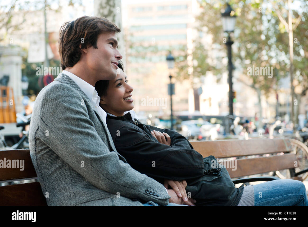 Couple relaxing on park bench Stock Photo - Alamy