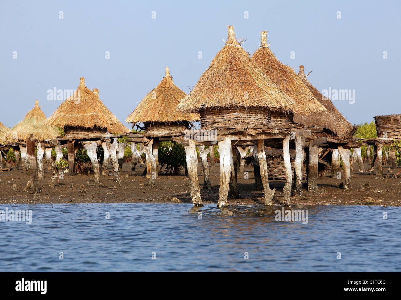 Island composed of shells with granaries on stilts out in the sea to protect from fire, Joal Fadiouth, Senegal Stock Photo