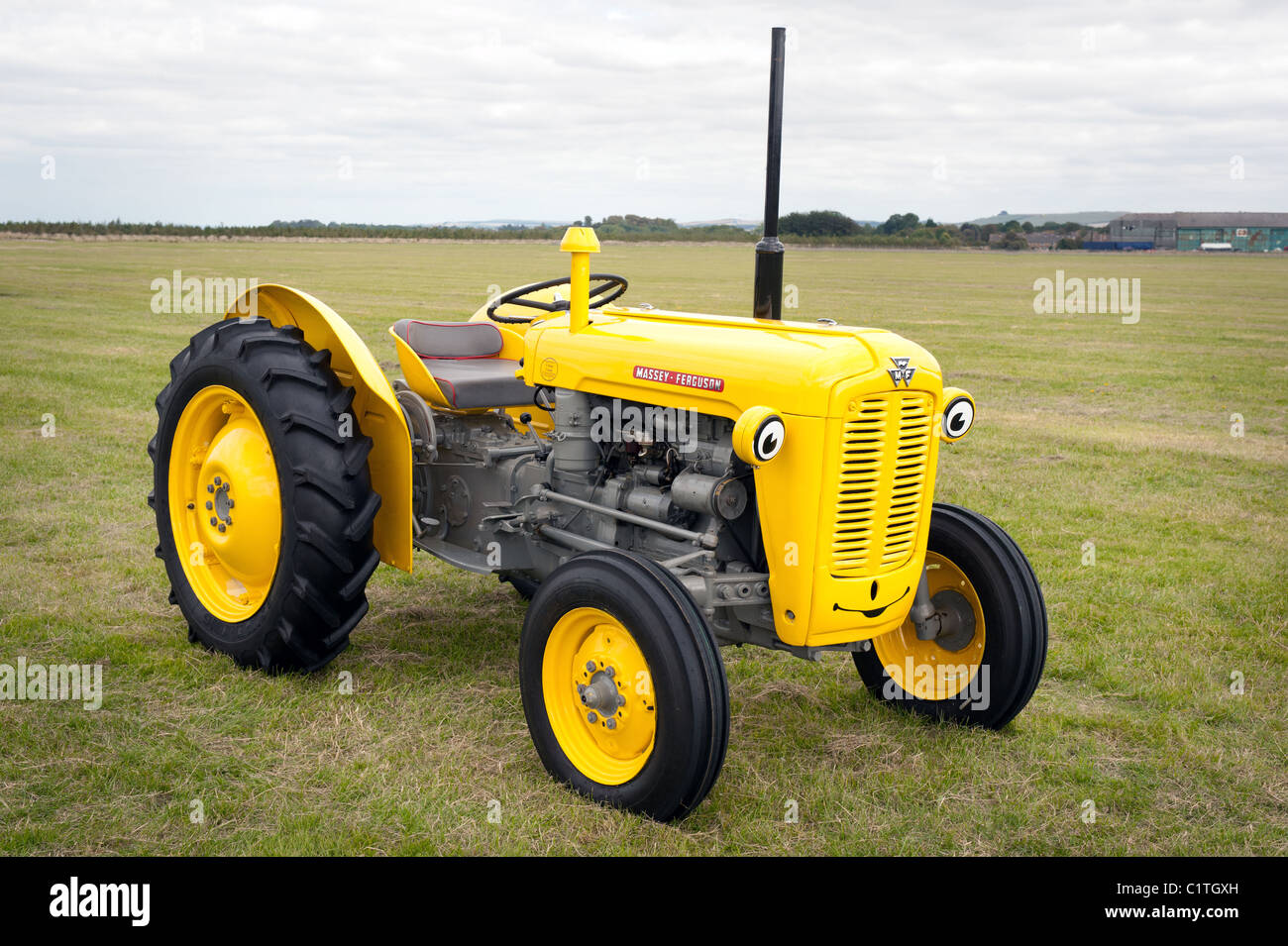 A Massey Ferguson Model 35 painted yellow and grey with a smiley face Stock Photo