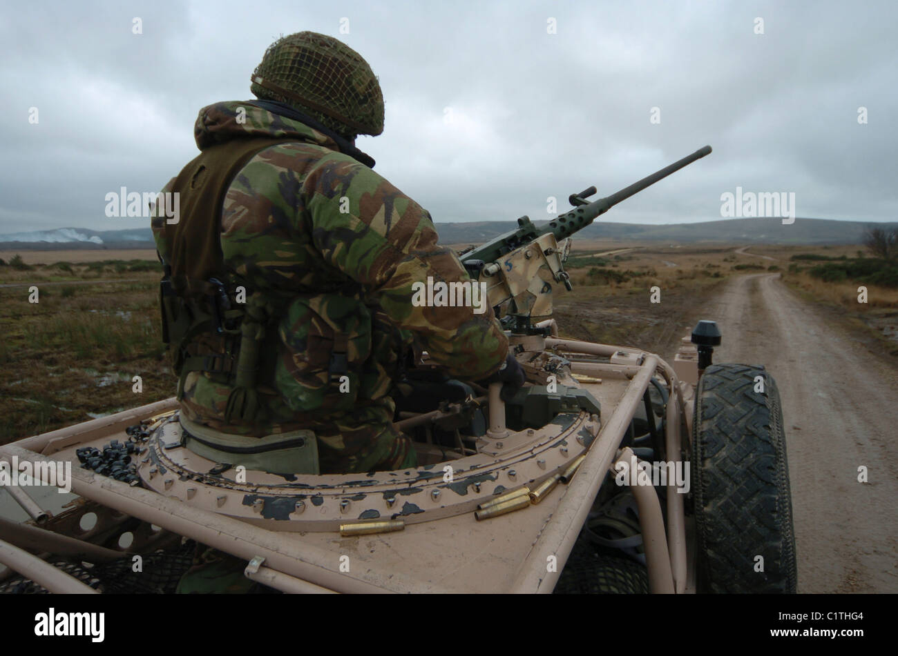 A soldier manning a .50 caliber heavy machine gun atop a Pink Panther Land Rover in Brecon, Wales. Stock Photo