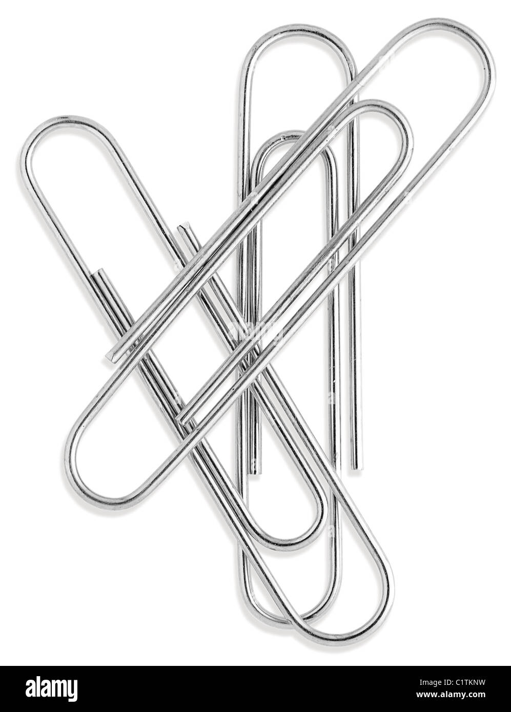 a small group of silver paperclips isolated on a white background from overhead Stock Photo