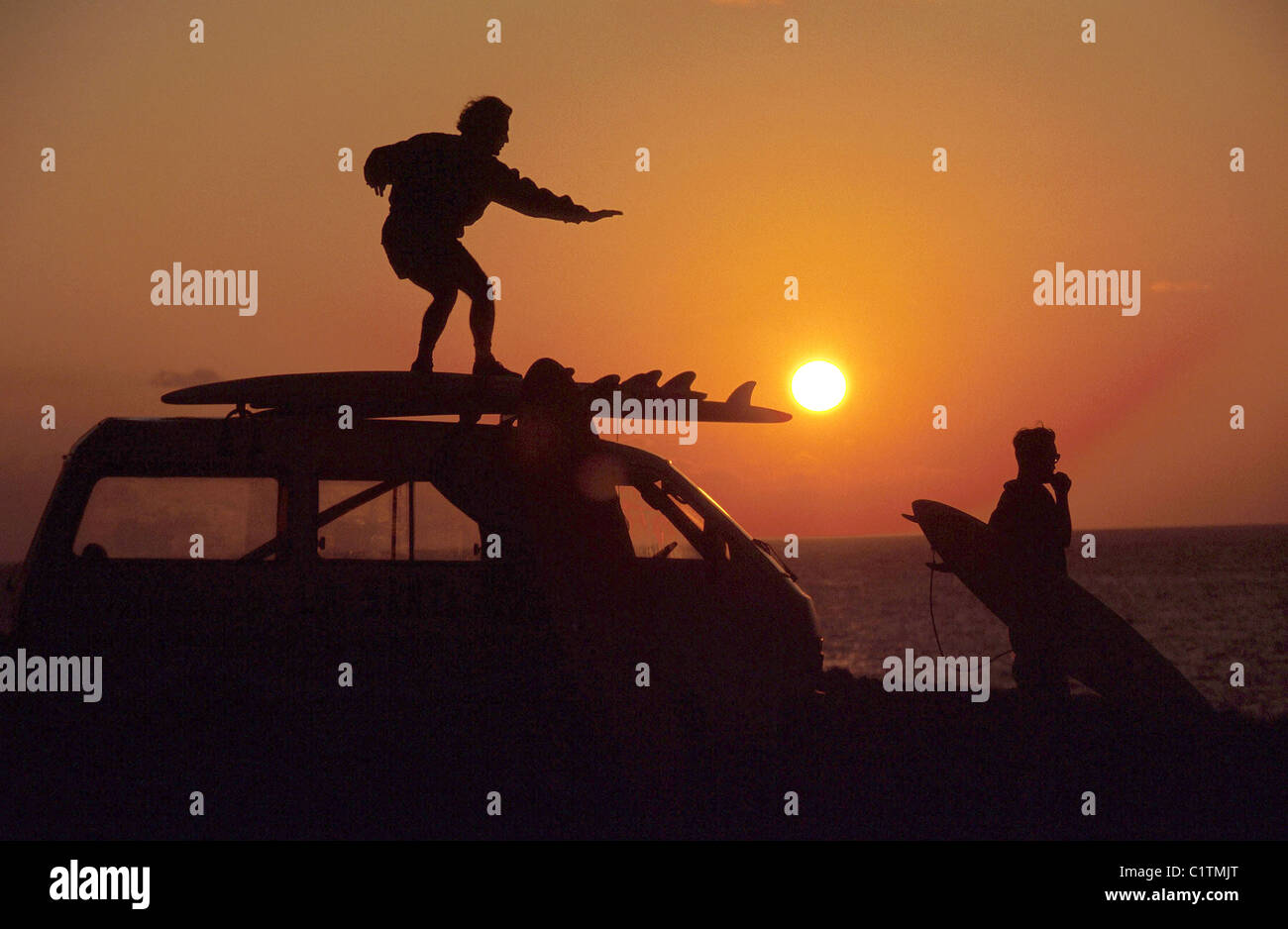 Silhouettes of two young men on beach at sunset Stock Photo - Alamy