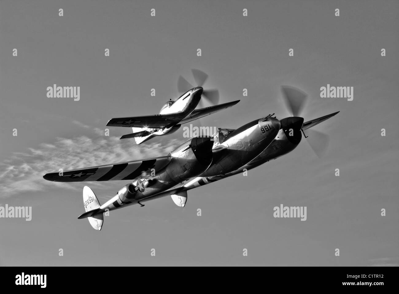 A P-38 Lightning and P-51D Mustang in flight over Chino, California. Stock Photo