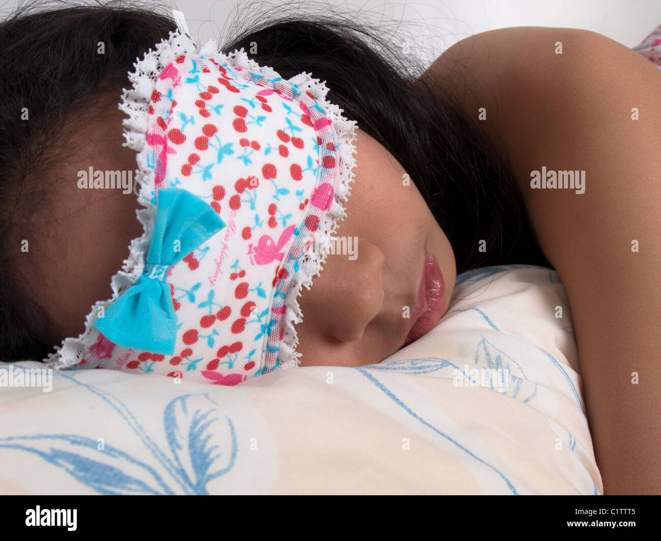 A teenage girl sleeping with a sleeping mask on. Stock Photo