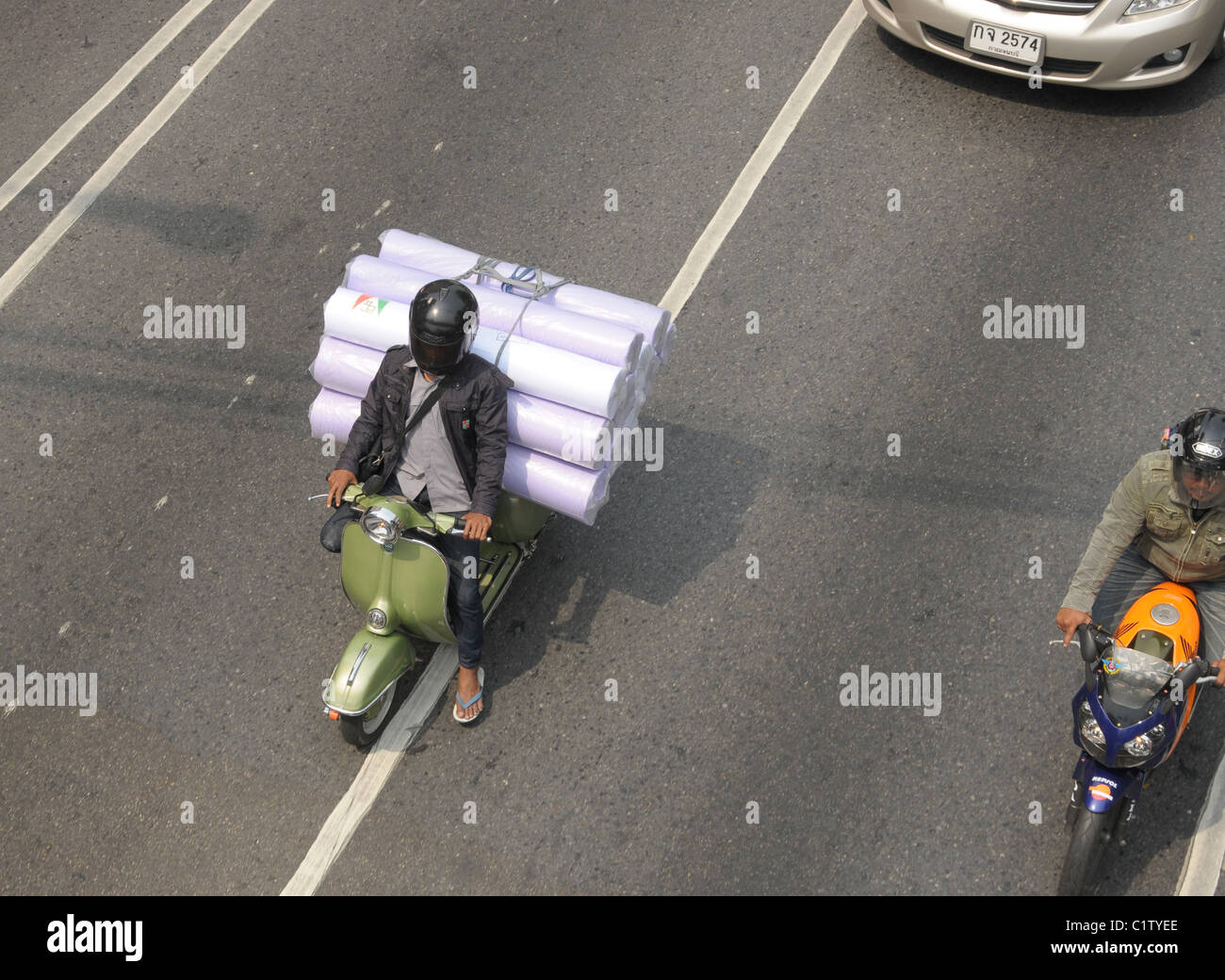 overloaded motorbike delivery guy , bangkok street , chinatown, bangkok, thailand Stock Photo
