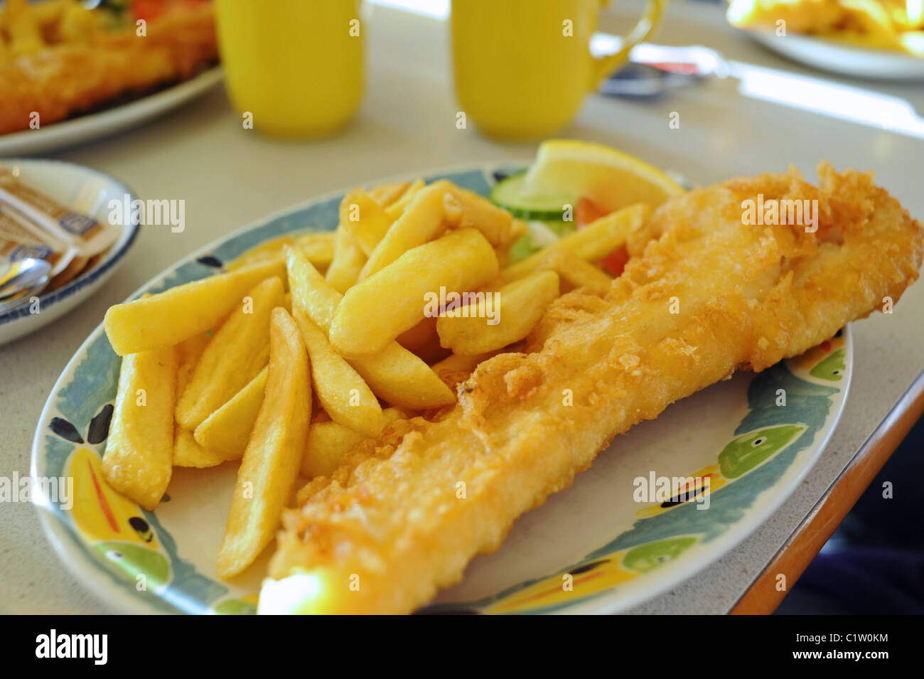 Traditional British plate of fish and chips served up in a seaside town cafe UK Stock Photo