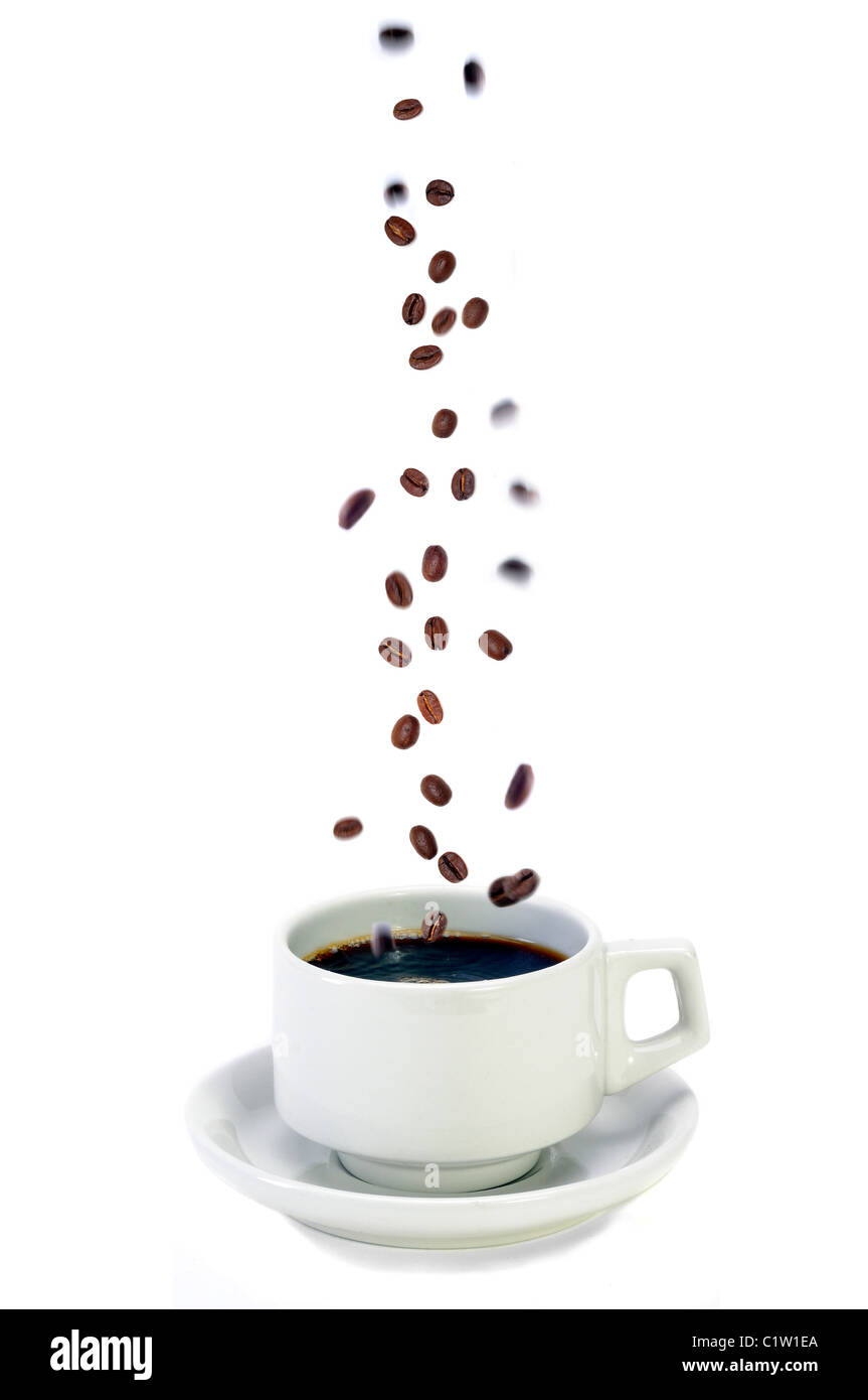 Fresh Colombian Coffee Beans Falling Into A Freshly Brewed Cup Of