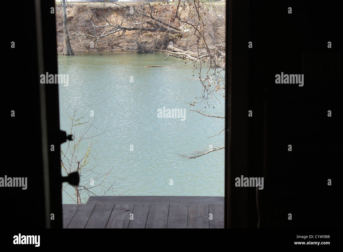 this is a photo of a river as seen by looking through a door to the outside.  The river and opposite bank are clearly visibl2. Stock Photo