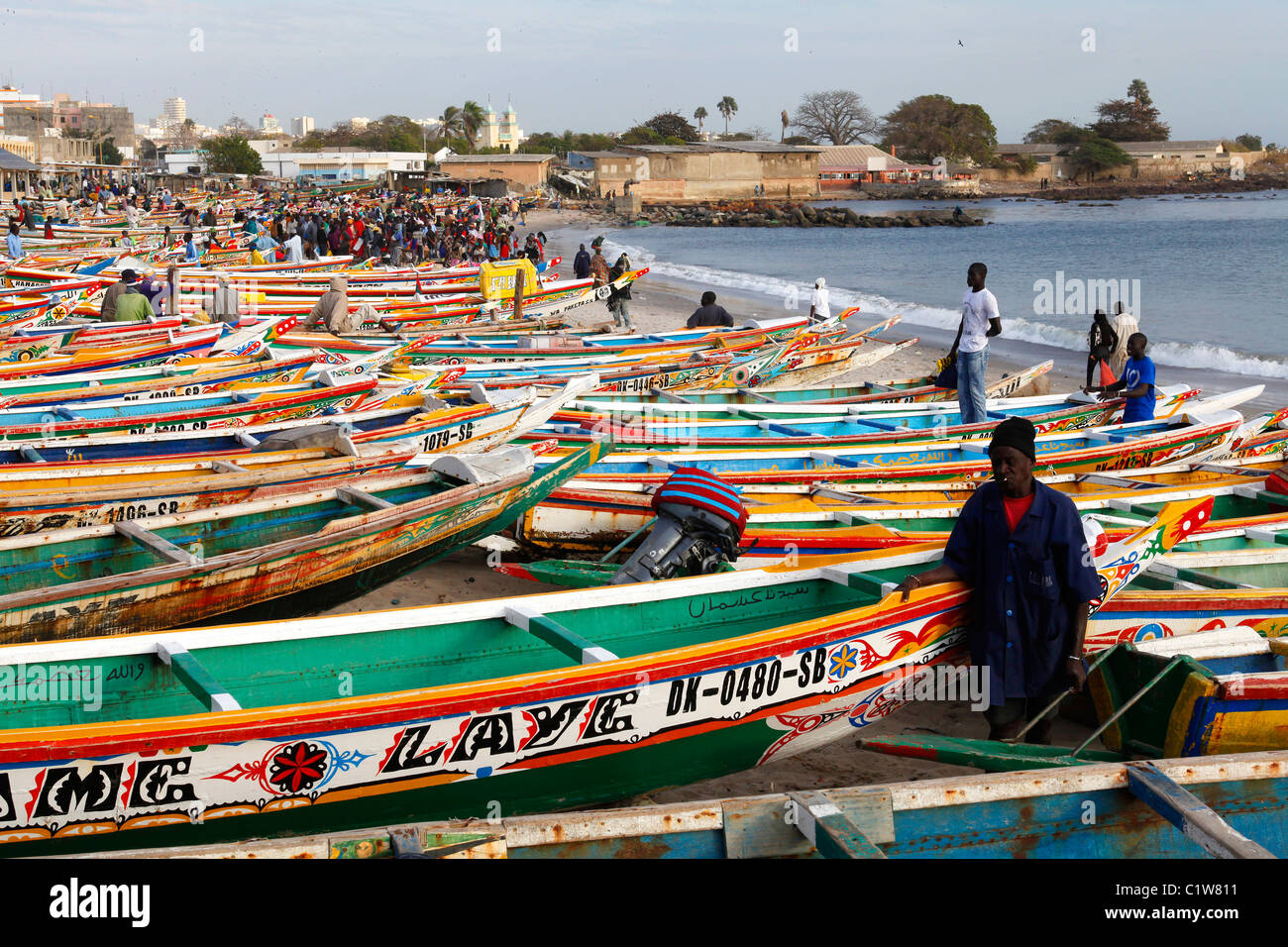 Colorfully painted fishing boats line the beach at the fish market in Dakar, Senegal Stock Photo