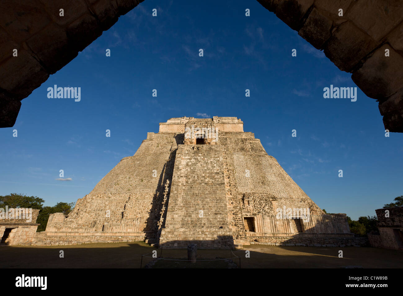 Pyramid of the Magician (Pirámide del Adivino) framed by a Corbel Arch from the Nunnery, in the Maya City of Uxmal, Mexico. Stock Photo