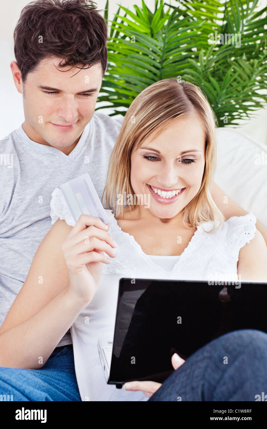 young couple using laptop siting on a sofa Stock Photo - Alamy