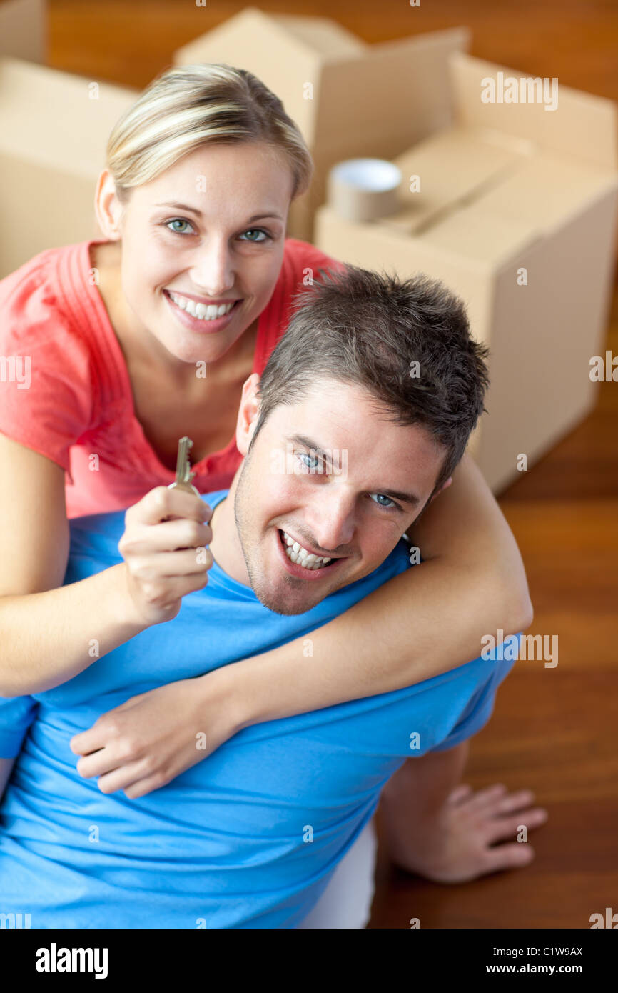 Portrait of a joyful couple in their new house with woman showing the key Stock Photo