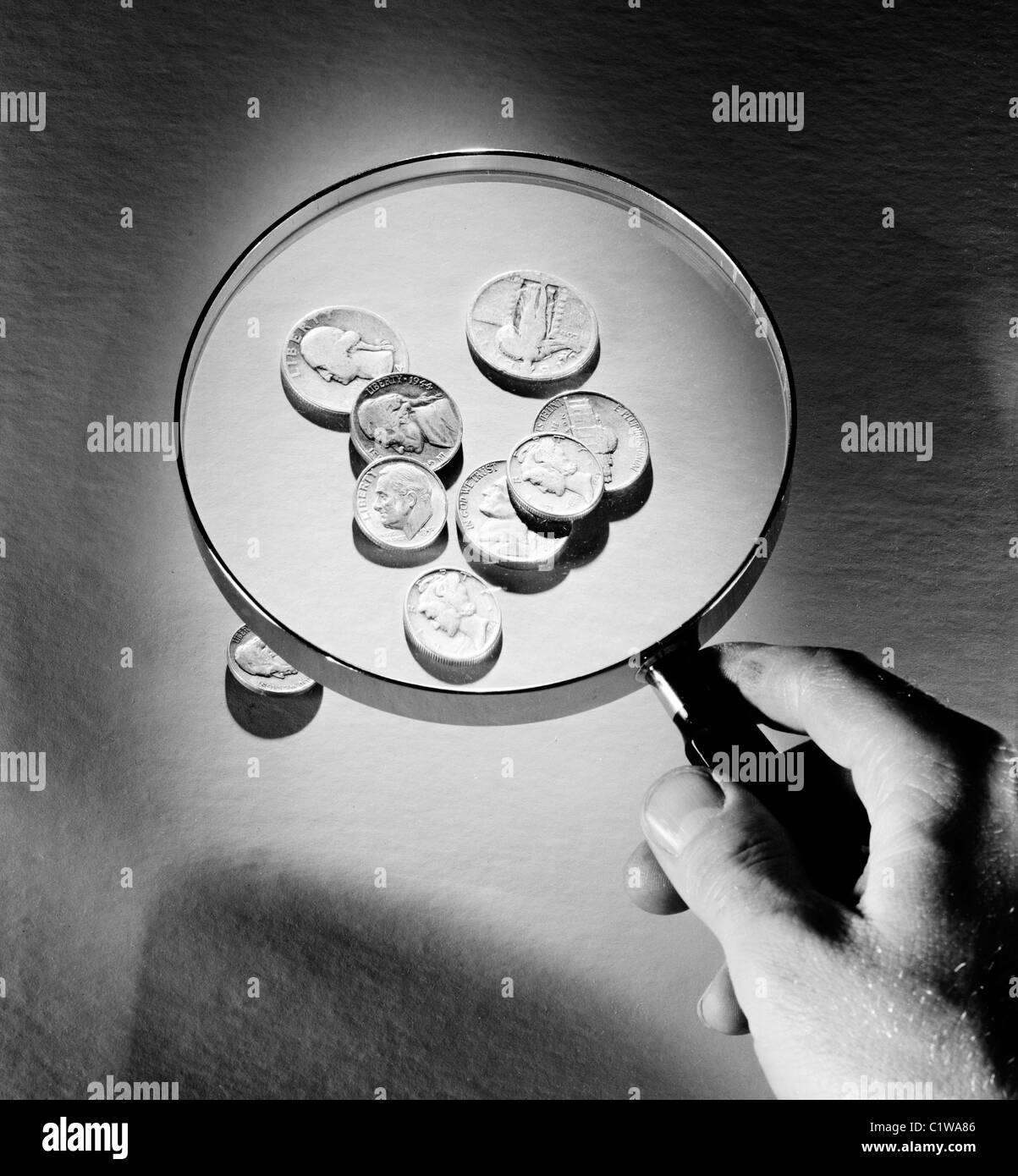 Coins under magnifying glass Stock Photo - Alamy