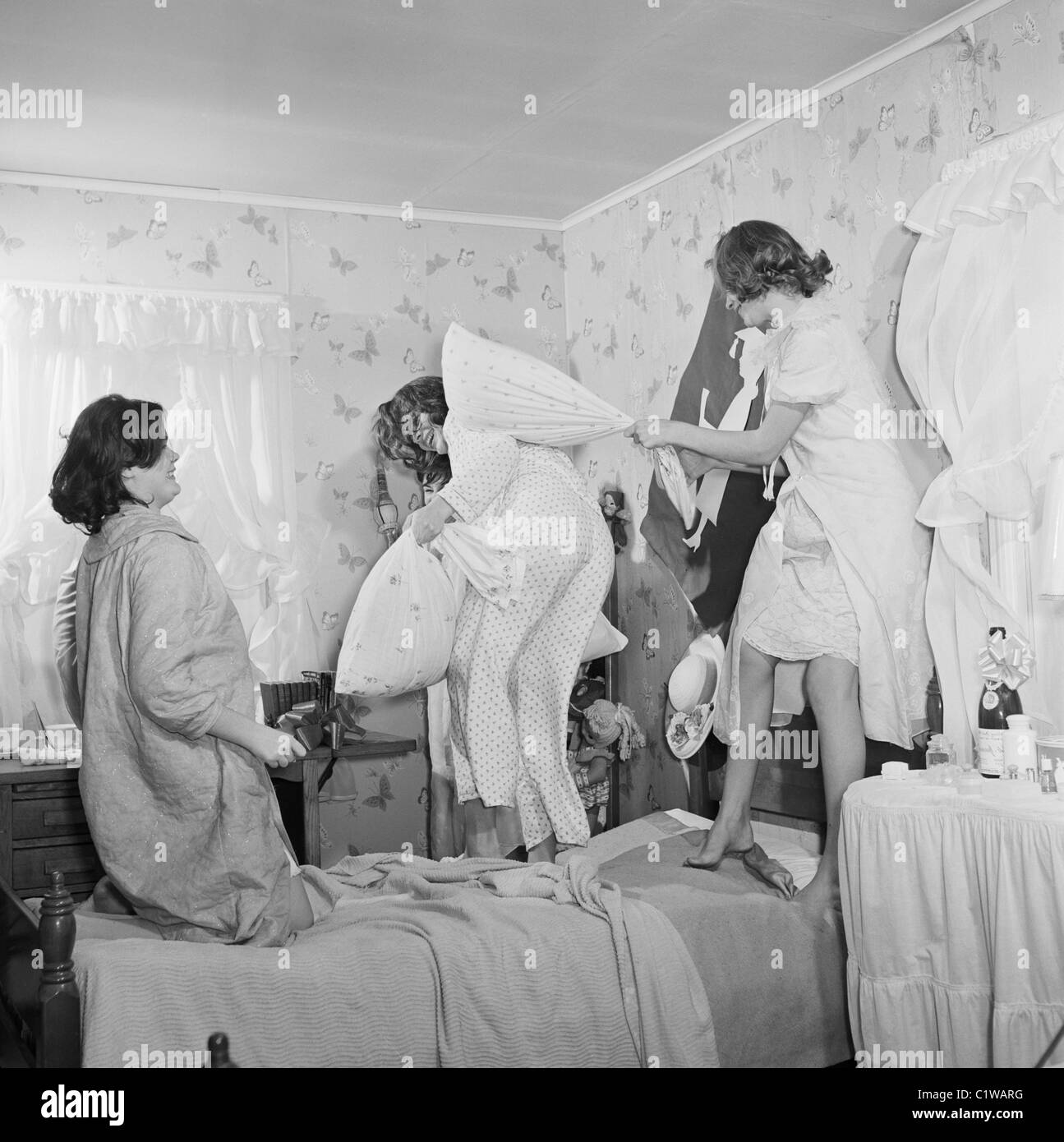 Four young women having pillow fight in bedroom Stock Photo - Alamy