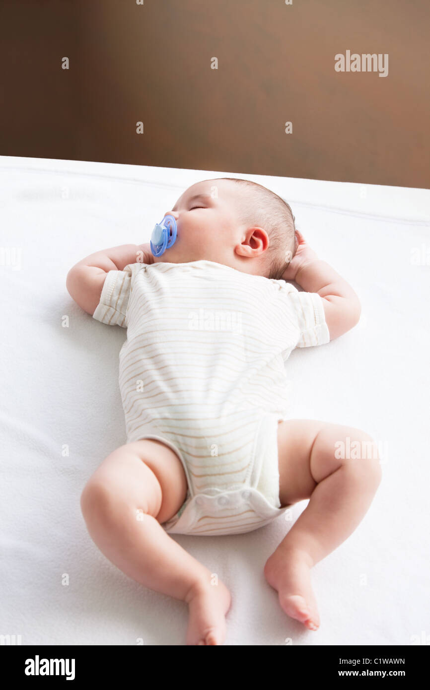 Portrait of a sweet baby with a pacifier sleeping on the sofa in the