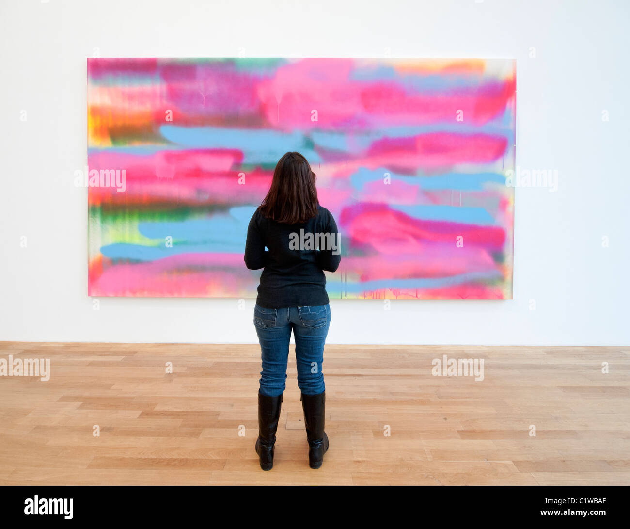 Woman looking at modern art painting By Katharina Grosse at Bonn Kunstmuseum in Germany Stock Photo