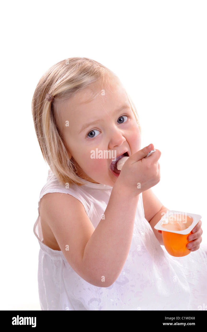 little girl eating yogurt, mouth wide open. isolated on white Stock