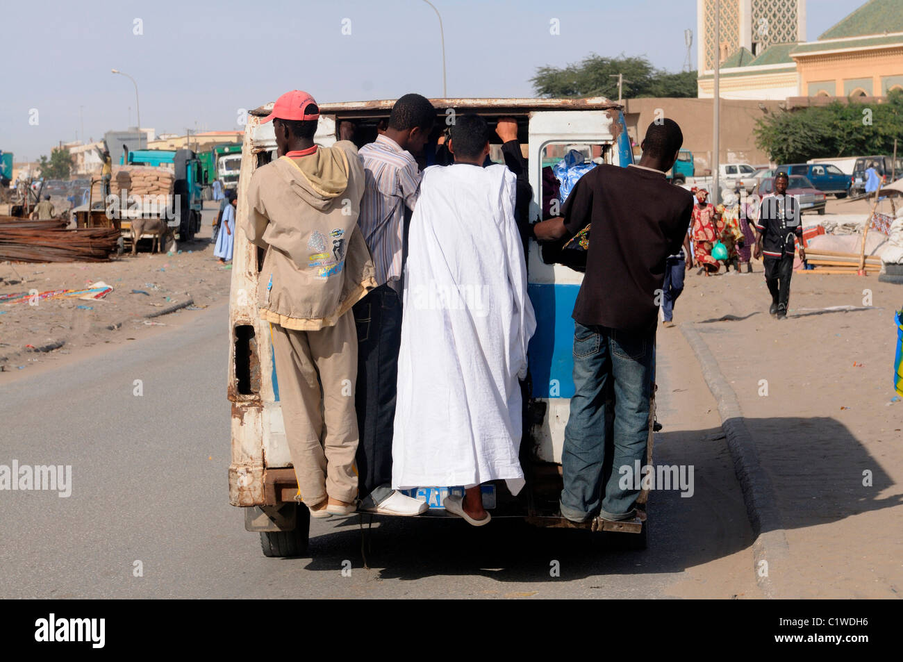 Mauritania, Nouakchott, Passengers standing on back of van Stock Photo