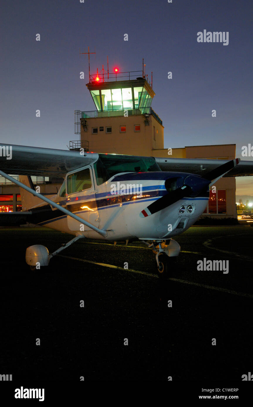 Small plane Cessna 172 parked by night front of control tower, Nancy Essey airport, Lorraine, France Stock Photo