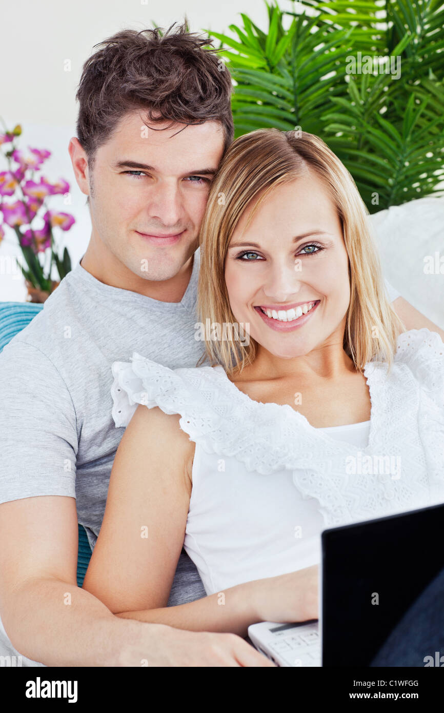 Portrait of a Young couple with laptop relaxing on the sofa Stock Photo ...