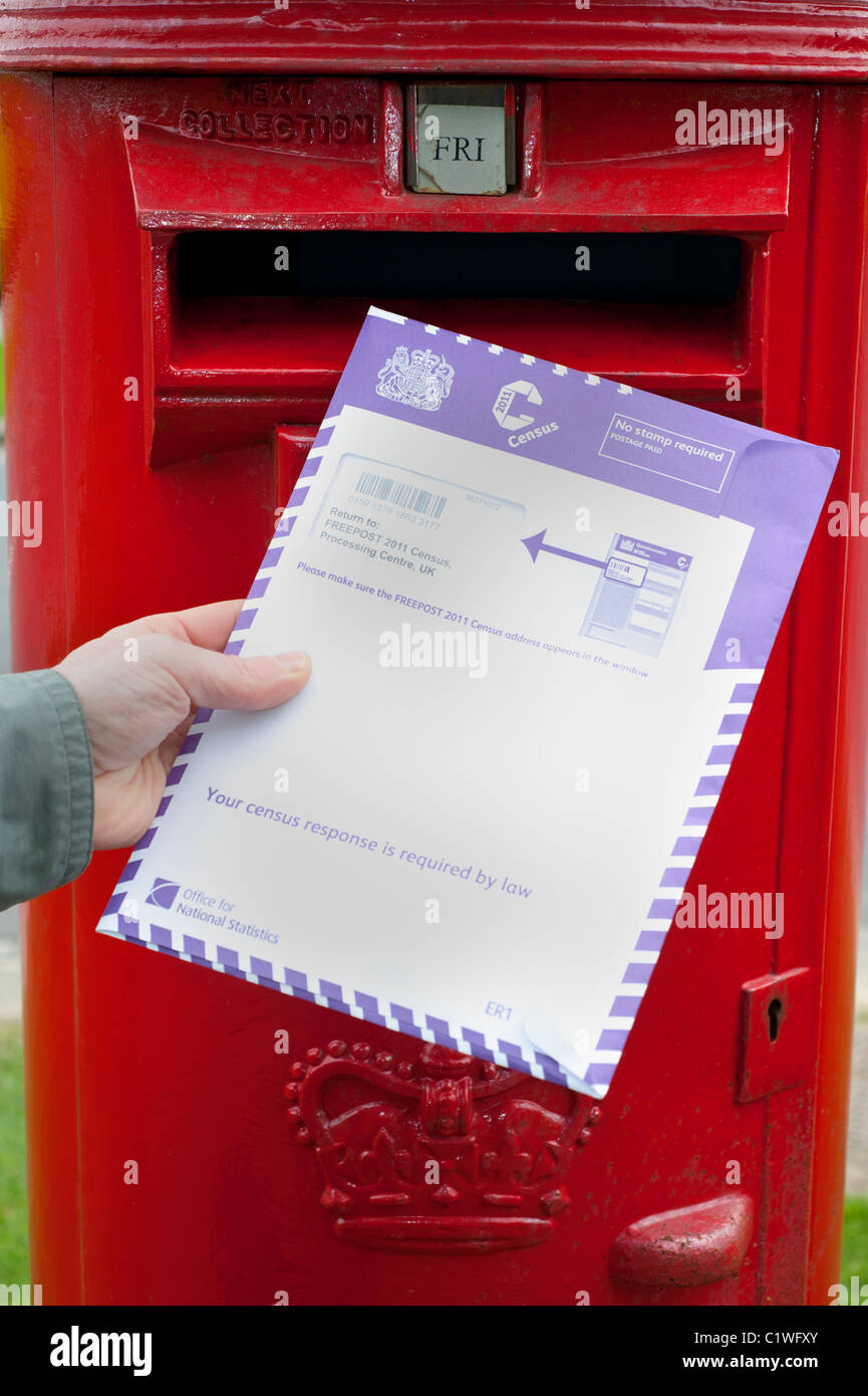person posting completed census form in post box uk Stock Photo - Alamy